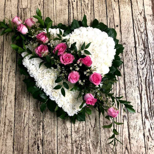 Heart-shaped floral arrangement with pink roses and white flowers
