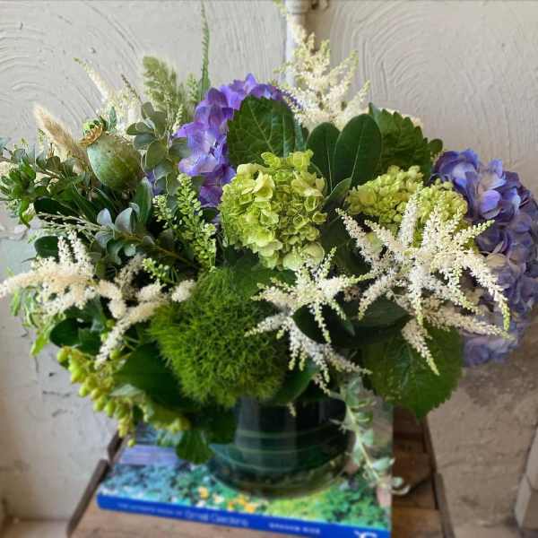 Purple hydrangeas and white astilbe in a glass vase
