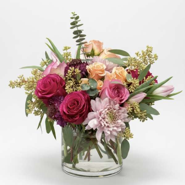 Mixed pink and peach bouquet in a clear glass vase