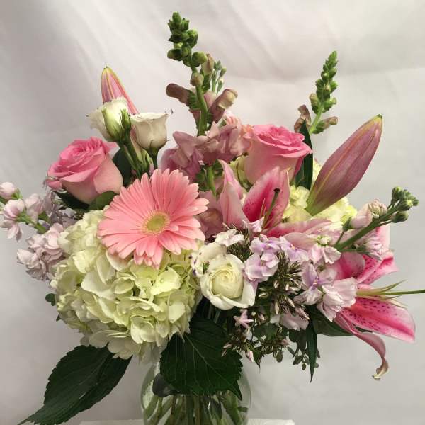 Mixed pink and white flowers arranged in a glass vase