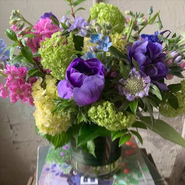 Bouquet of purple, pink, and green flowers in a glass vase