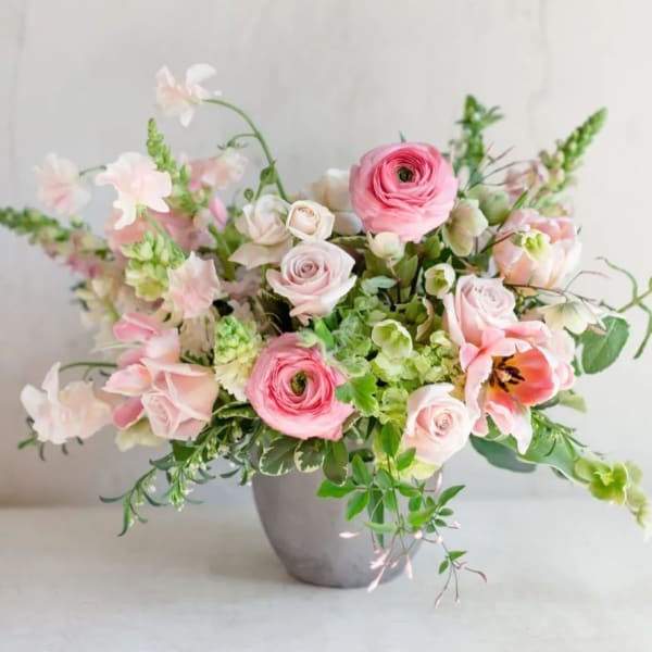 Pink and white floral arrangement in a gray vase