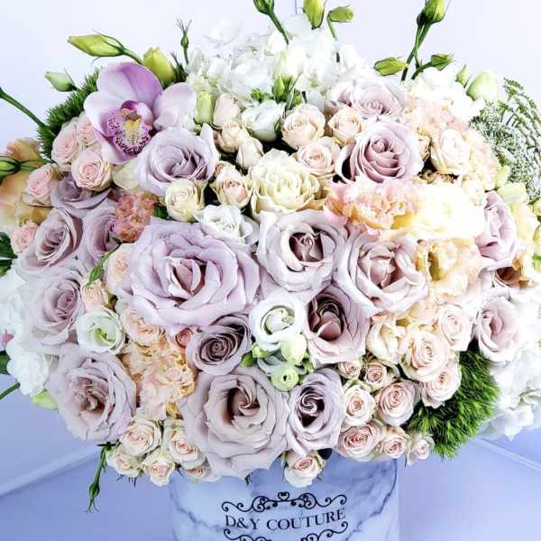Large pastel bouquet in a marble-print hatbox with roses and orchids