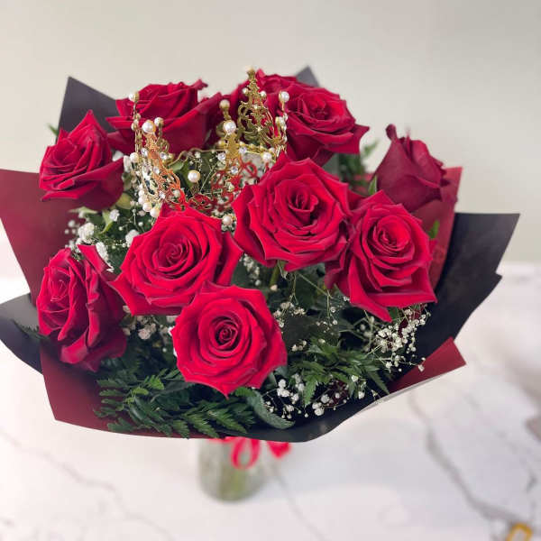 Bouquet of red roses with a small gold crown topper
