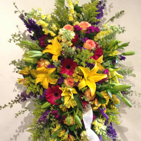 Large standing spray with yellow lilies, pink roses, and purple flowers