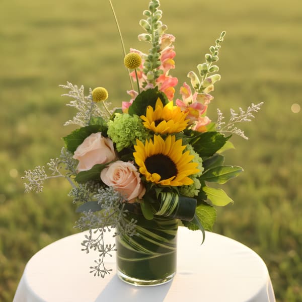 Sunflowers and pale pink roses in a glass vase