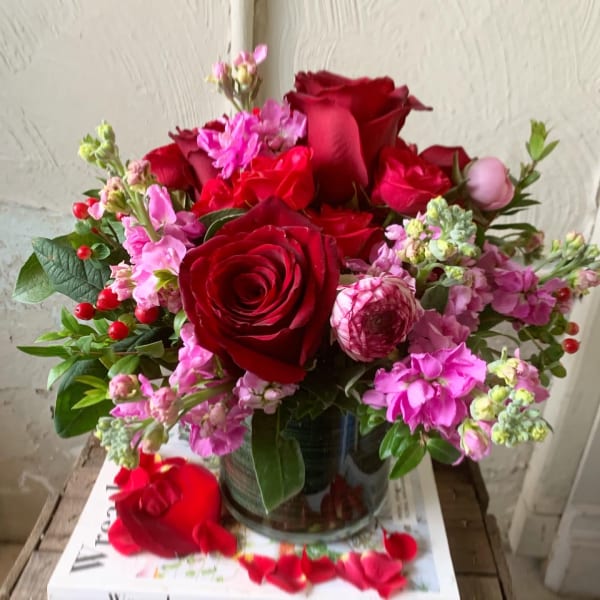 Bouquet of red roses and pink flowers in a glass vase