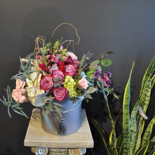 Mixed pink and purple bouquet in a blue hatbox