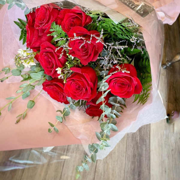 Bouquet of red roses wrapped in pink paper