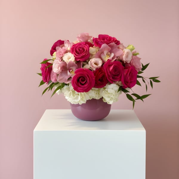 Pink and white rose bouquet in a purple vase