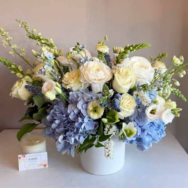 Blue and white floral arrangement in a white vase