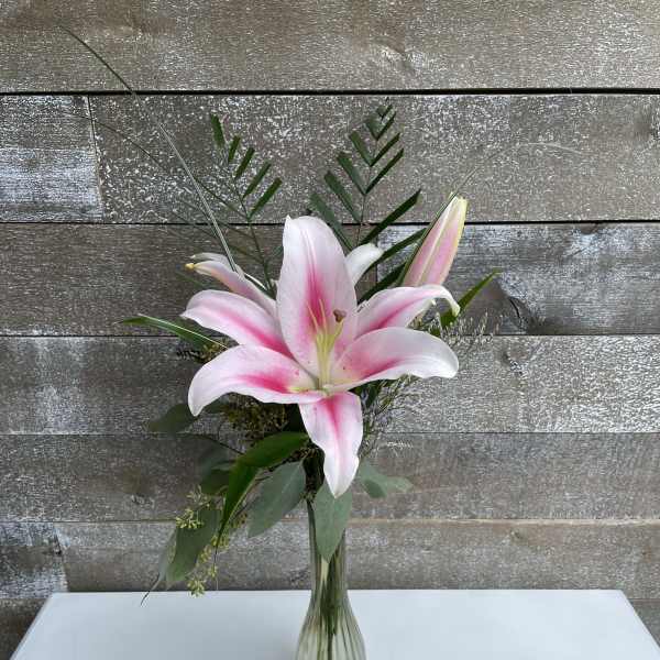 Pink lily arrangement in a clear glass vase