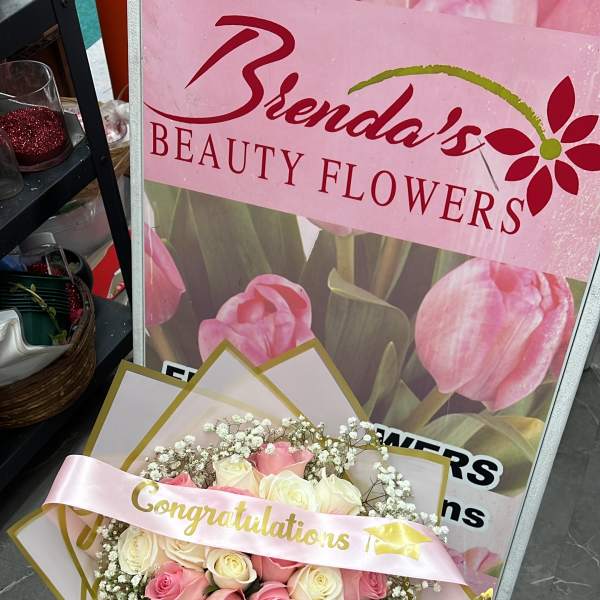 Pink and white rose bouquet with a congratulations ribbon