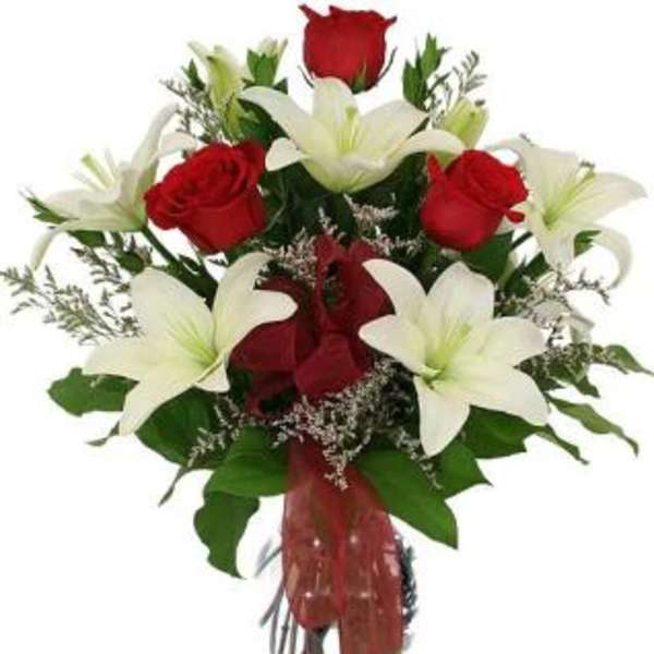 Bouquet of red roses and white lilies in a glass vase