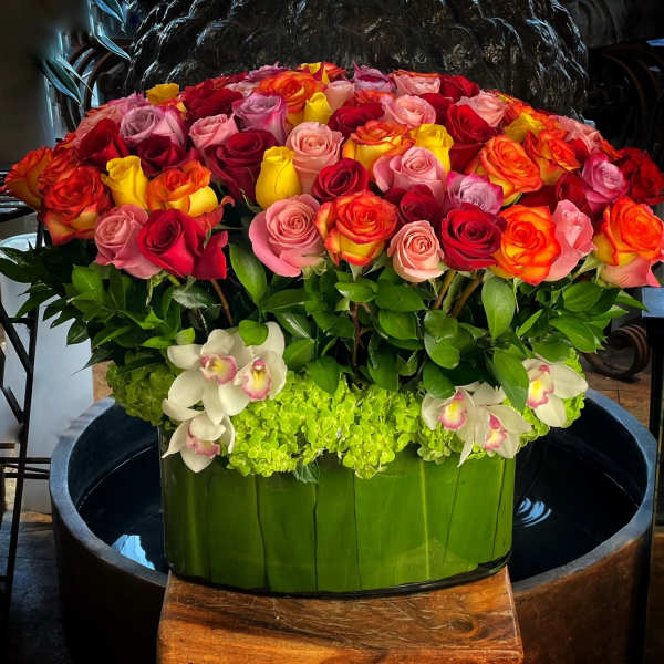Large arrangement of multicolored roses in a green container