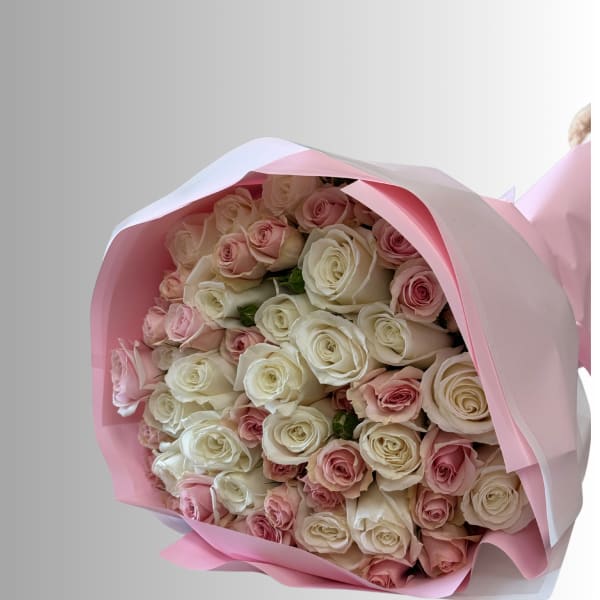 Bouquet of pink and white roses wrapped in pink paper