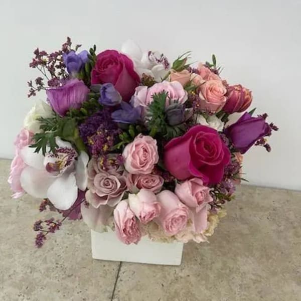 Mixed pink, purple, and white bouquet in a white box