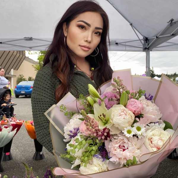 Woman holding a large bouquet of pink and white flowers