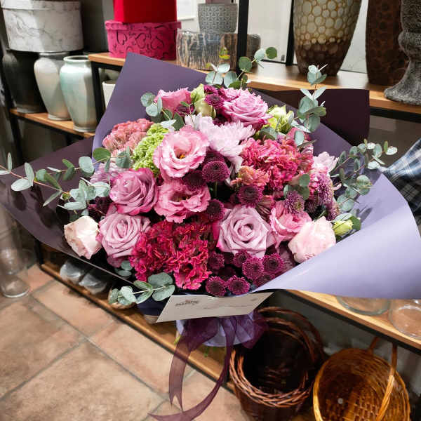 Bouquet of pink and purple flowers wrapped in lavender paper