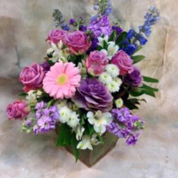 Pink and purple mixed bouquet with a pink daisy in a brown wrap