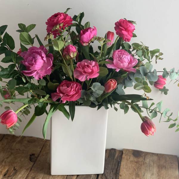 Pink flowers arranged in a white rectangular vase