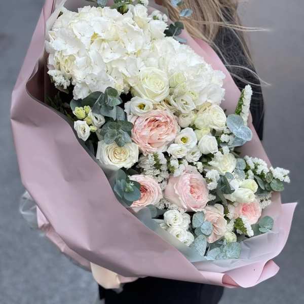 Large bouquet of white and blush flowers wrapped in pink paper