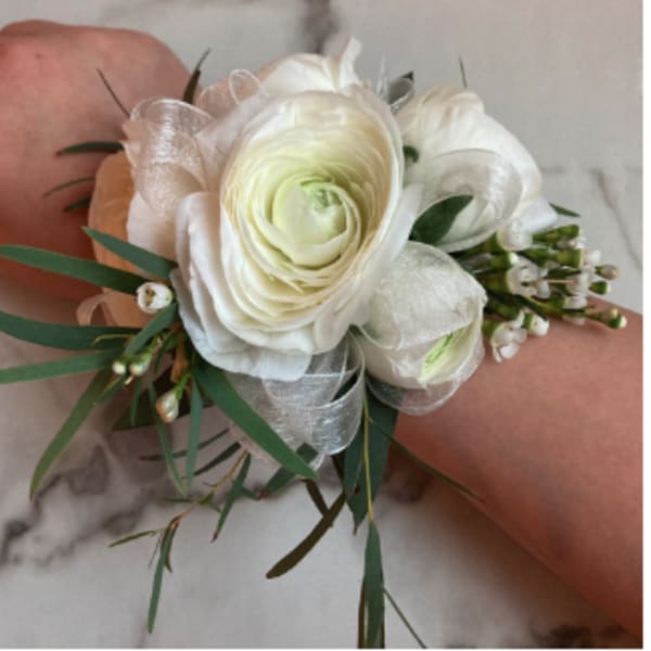 White floral wrist corsage with ribbon and greenery