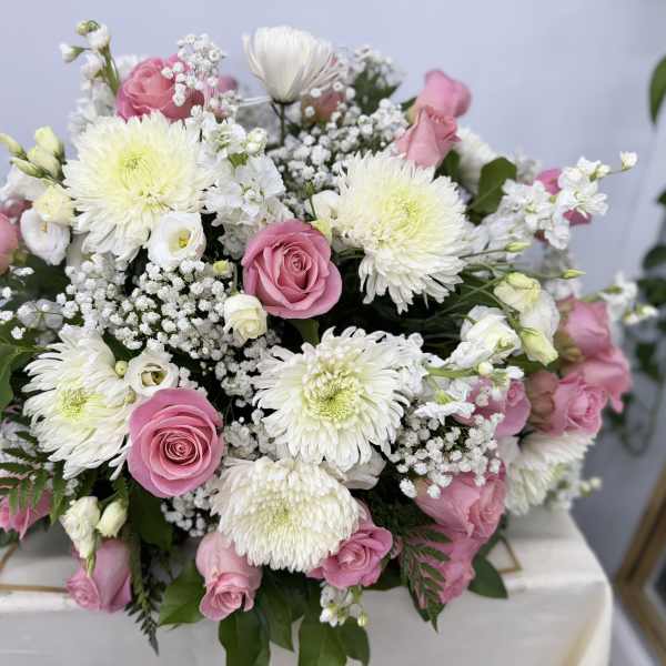 Pink roses and white chrysanthemums arranged in a low bouquet
