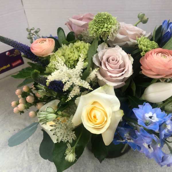 Mixed bouquet with roses, ranunculus, and blue flowers