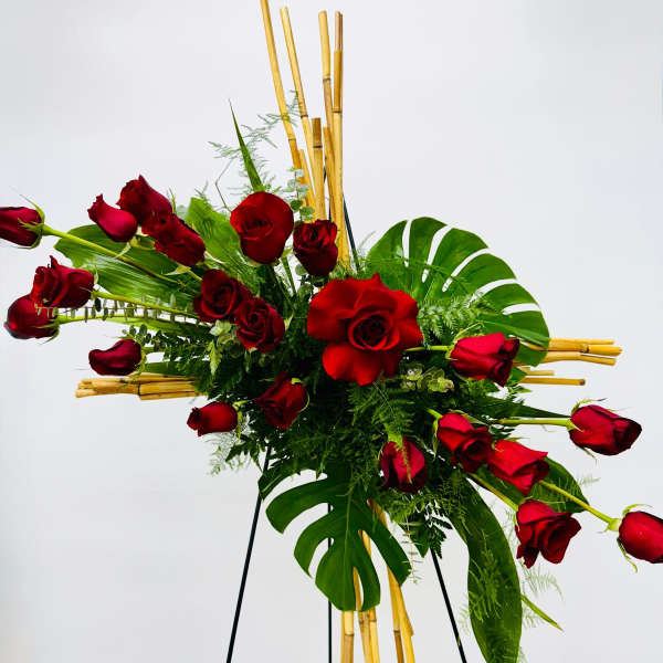 Red roses arranged with tropical leaves on a stand