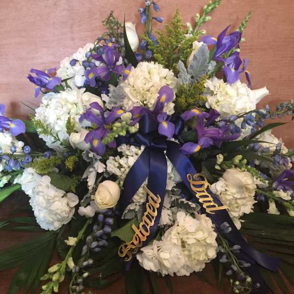 White and purple floral spray with ribbon on a table