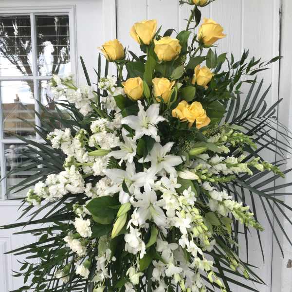 Large standing spray of yellow roses and white lilies with orchids