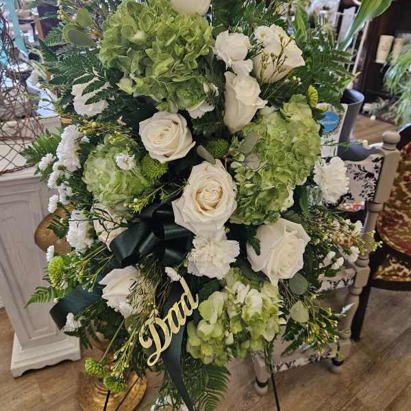 Tall floral standing spray with white roses and green hydrangeas