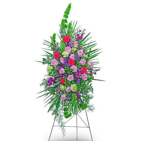 Standing floral spray with pink roses and bright mixed flowers on an easel
