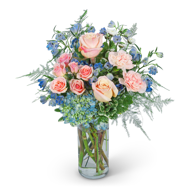 Pink roses and blue flowers in a clear glass vase