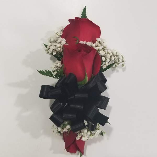 Two red roses with white baby's breath and a black ribbon