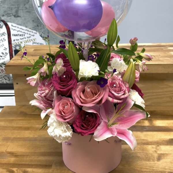 Pink and purple flower arrangement with a clear birthday balloon