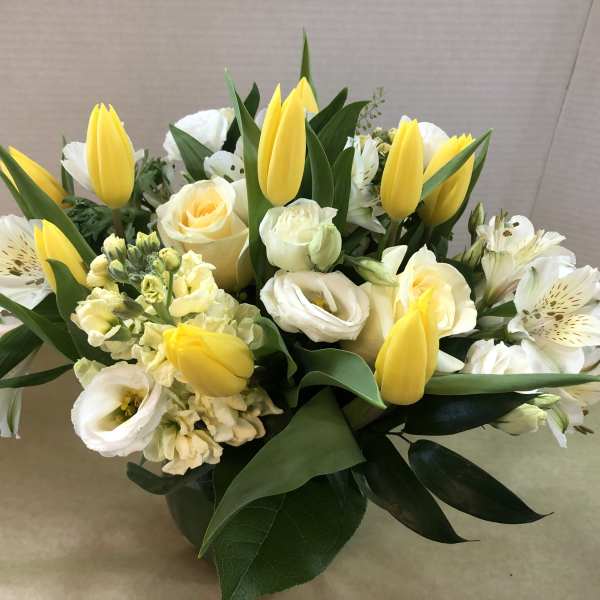 Bouquet of yellow tulips and white flowers with greenery