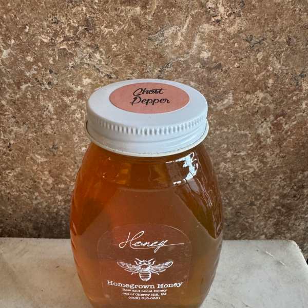 Jar of honey with a white lid on a countertop