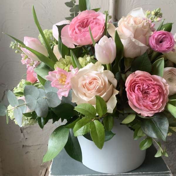 Pink and cream roses with tulips in a white vase