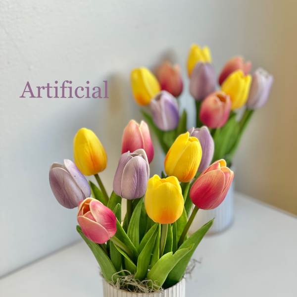 Artificial tulips in a small striped pot