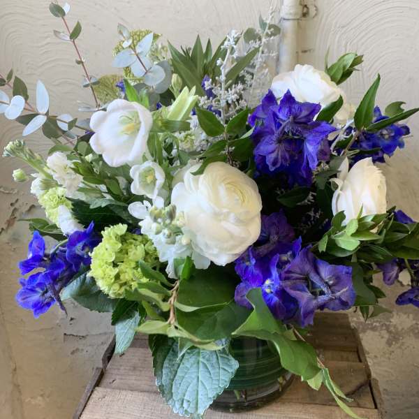 White and purple flowers arranged in a glass vase