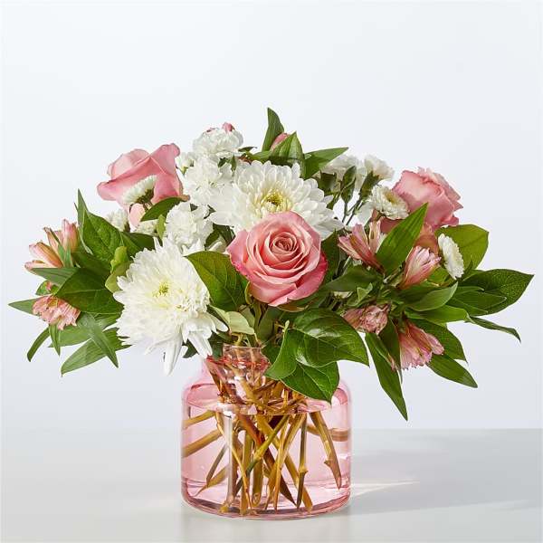 Pink roses and white daisies in a pink glass vase