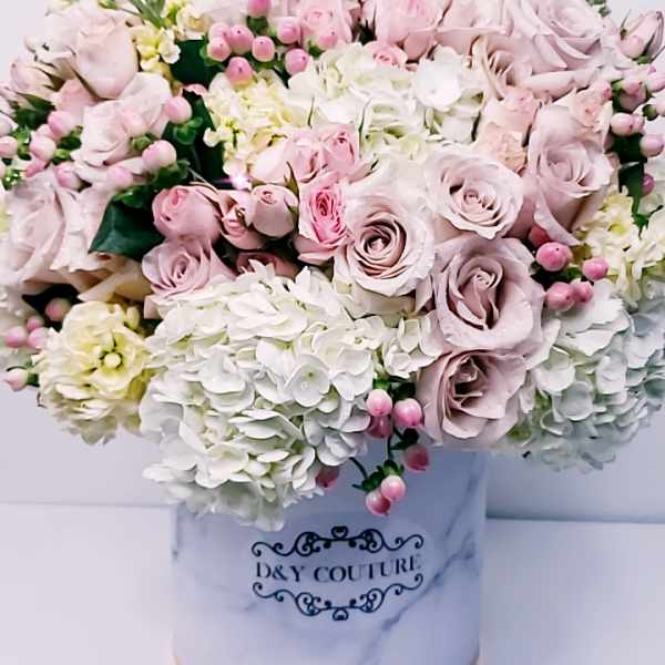 Pink and white rose arrangement in a marble-patterned hat box