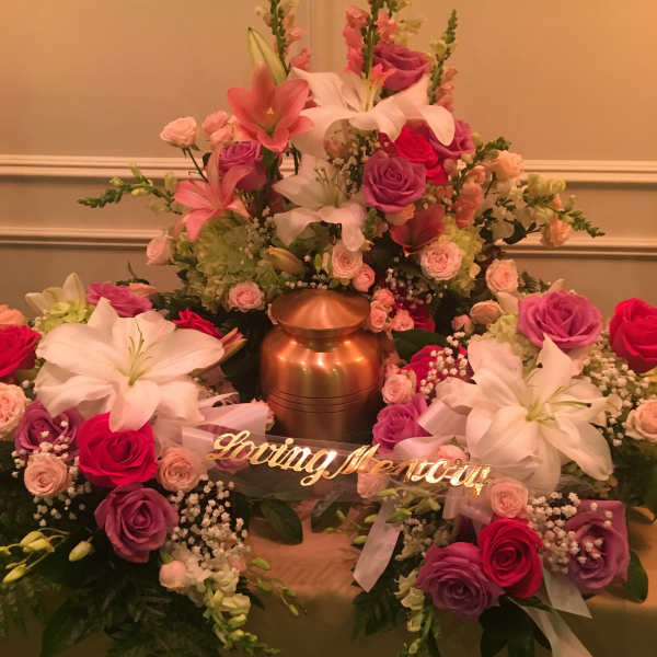 Large floral funeral arrangement with pink and white lilies and roses