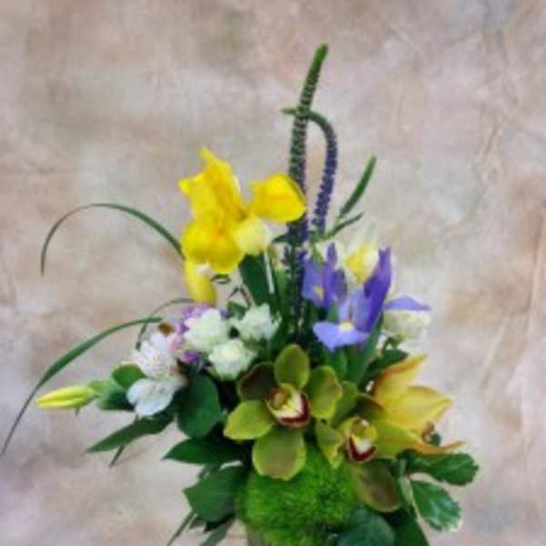 Mixed bouquet with yellow and purple flowers in a glass vase