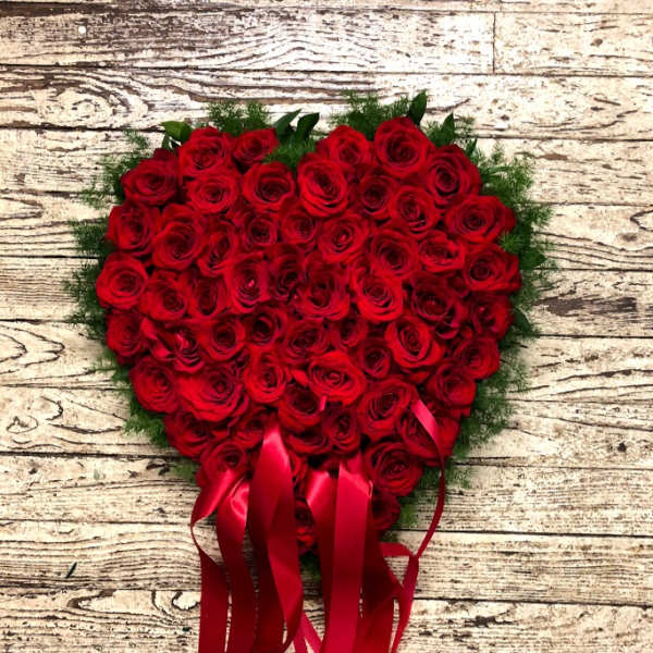 Heart-shaped bouquet of red roses with long red ribbons