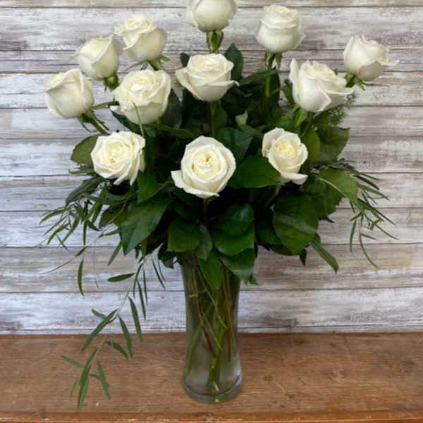 White roses arranged in a clear glass vase