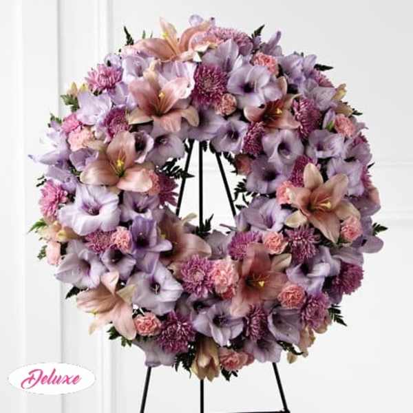 Lavender and pink floral wreath on a black stand