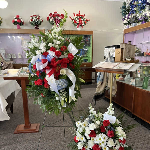 Two large floral standing sprays with red, white, and blue flowers